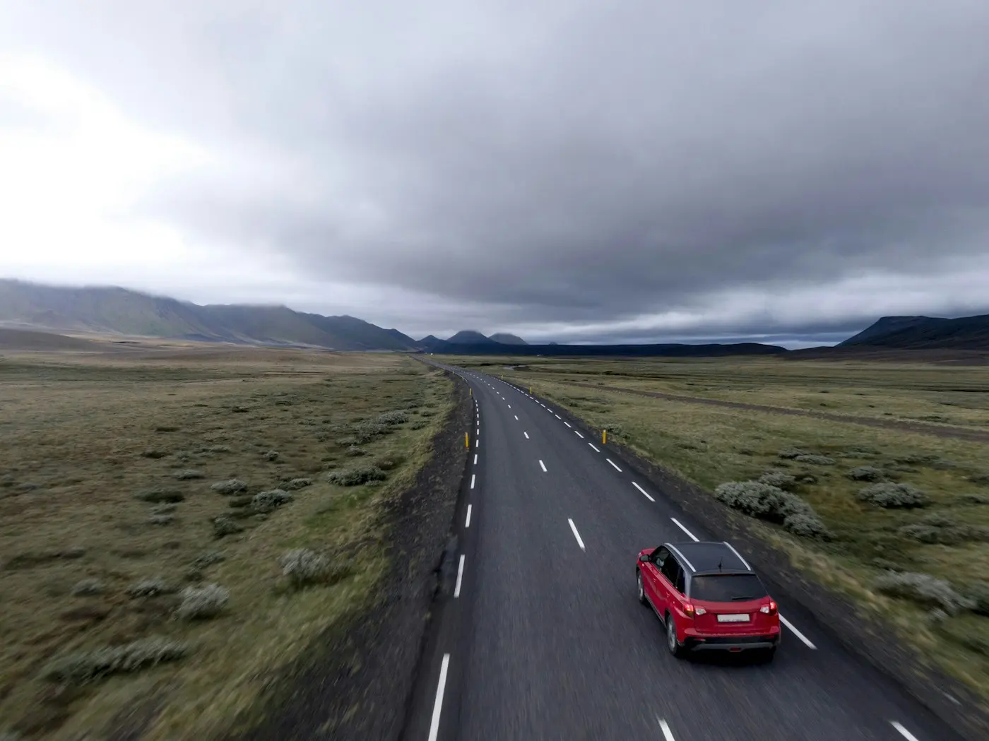 Red hatchback on a country road